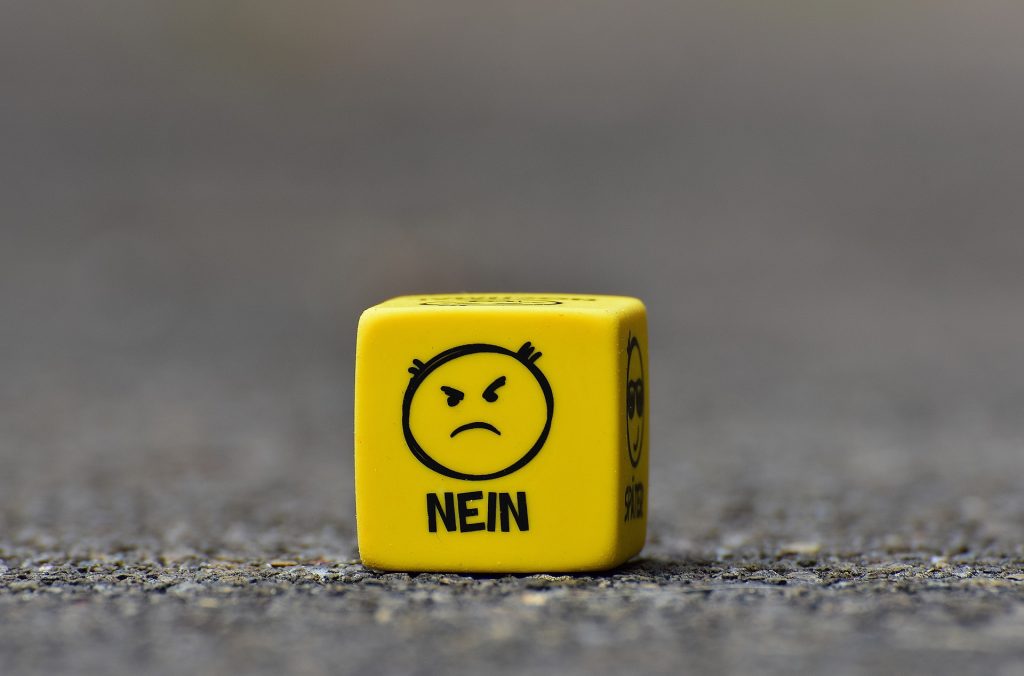 Das Bild zeigt einen gelben Würfel mit einem traurigen Smiley und darunter steht "nein".